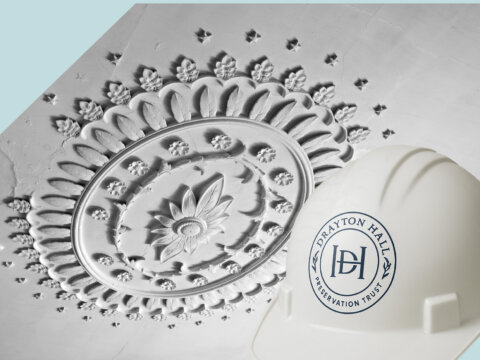 A decorative ceiling medallion with a construction helmet featuring the Drayton Hall Preservation Trust logo.