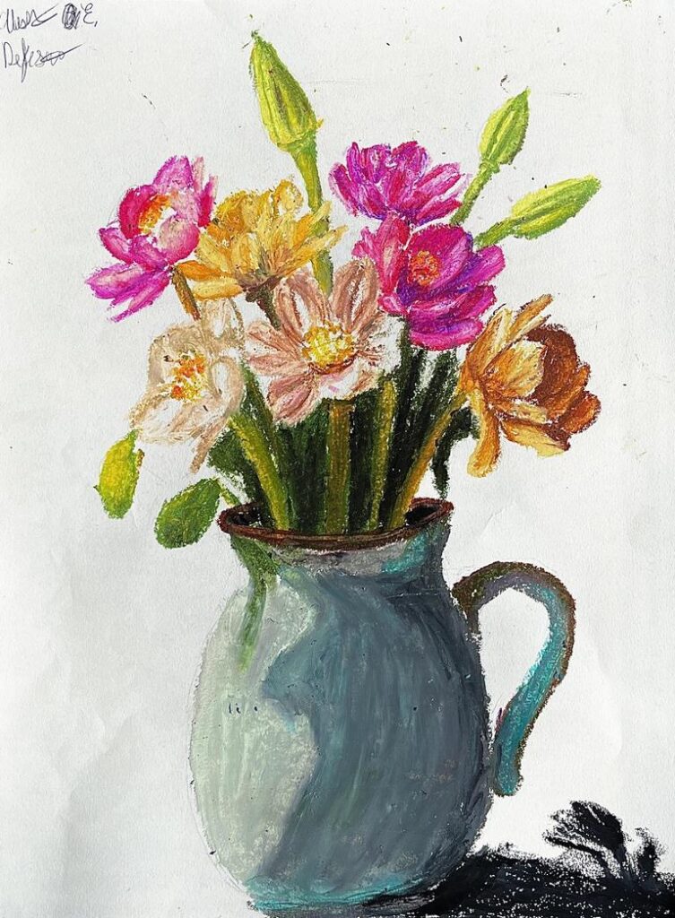 A vase filled with colorful flowers, including pink, orange, and yellow blooms, sits on a surface.