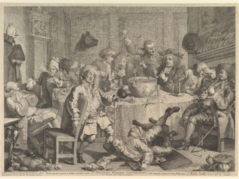 A lively gathering of men at a table, drinking and playing music, with one man standing and gesturing.